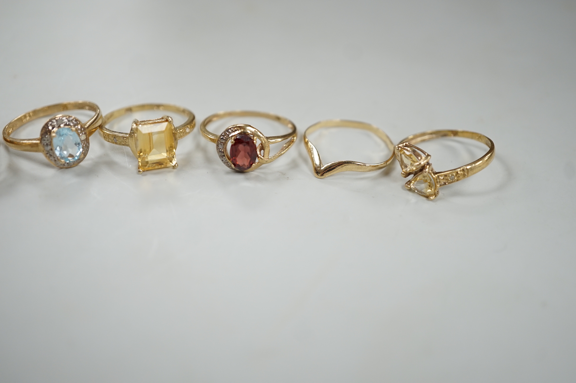 Five assorted modern 375 and gem set rings including amethyst and citrine, together with a 9ct wishbone shaped ring, gross weight 7.6 grams.